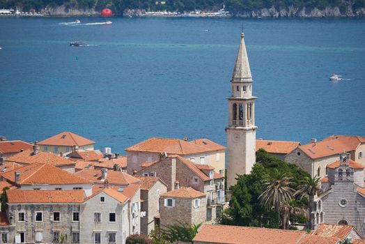 Old town with tower in Budva against sea.