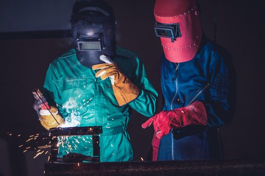 Metal welding steel works using electric arc welding machine to weld steel at factory. Metalwork manufacturing and construction maintenance service by manual skill labor concept.