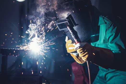 Metal welding steel works using electric arc welding machine to weld steel at factory. Metalwork manufacturing and construction maintenance service by manual skill labor concept.