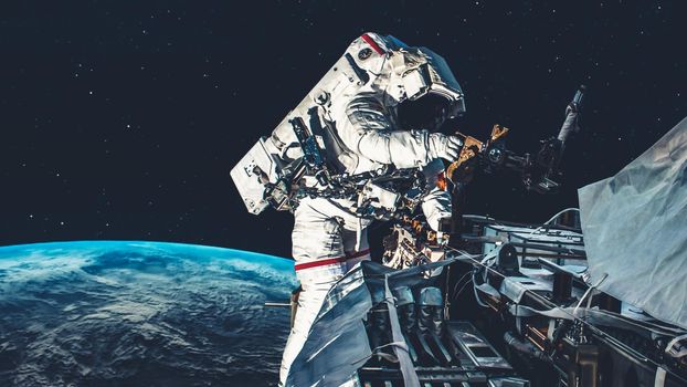 Astronaut spaceman do spacewalk while working for spaceflight mission at space station . Astronaut wear full spacesuit for operation . Elements of this image furnished by NASA space astronaut photos .