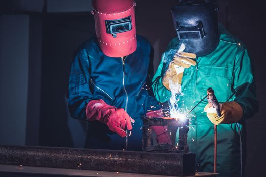 Metal welding steel works using electric arc welding machine to weld steel at factory. Metalwork manufacturing and construction maintenance service by manual skill labor concept.