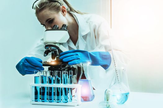 Young woman scientist working in chemical laboratory and examining biochemistry lab sample. Science technology medicine research and development study concept.