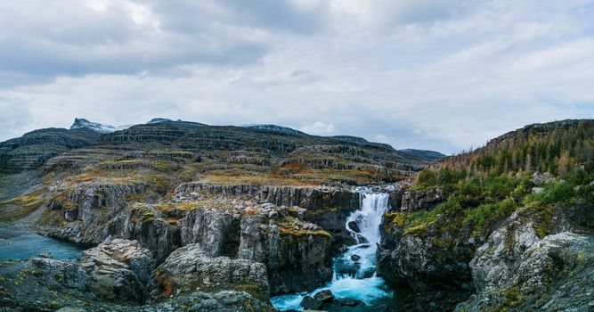 Spectacular winter landscape panorama with waterfall and mountain peaks