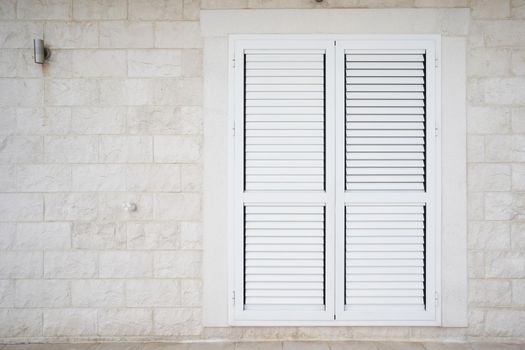 Plastic external window shutters on a residential building.