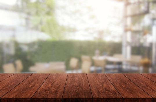 Wood table in blurry background of modern restaurant room or coffee shop with empty copy space on the table for product display mockup. Interior restaurant counter design concept.
