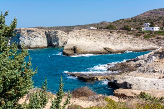 Milos island sea view with rocks, waves and small white houses