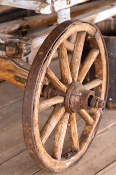 old wooden wheels are on the carriage at the ranch.