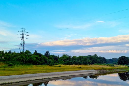 The concept of green energy in nature. On the bank of the river there is an electric station