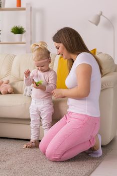 Happy child girl with cochlear implant having fun with her mother - hearing aid for deaf and innovative health technology