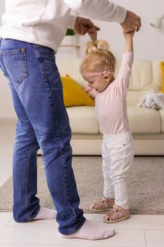 Baby with cochlear implants playing with her mother and father at home.