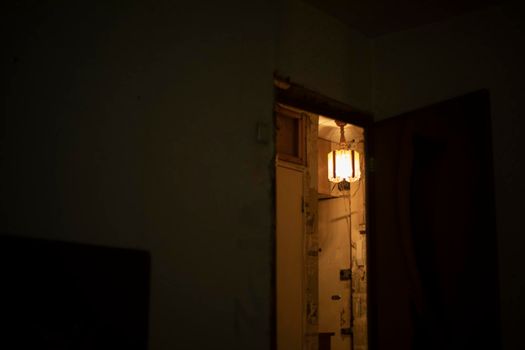 Light in room. Interior details. Lamp shines on ceiling. Doorway in house.