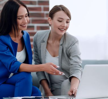 Young businesswomen working at office using a white laptop