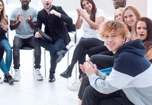 group of diverse young people applauding at a meeting. business and education