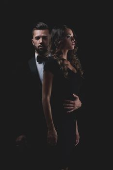 Full length picture of a young fashion couple standing on studio background.