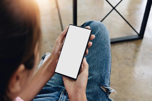 Close up above view of a woman using blank screen smartphone.
