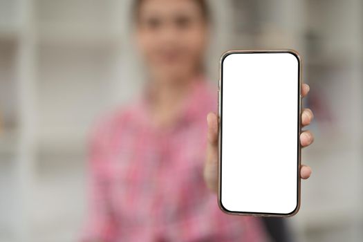 Mockup image of a beautiful woman holding and showing a mobile phone with blank white screen.