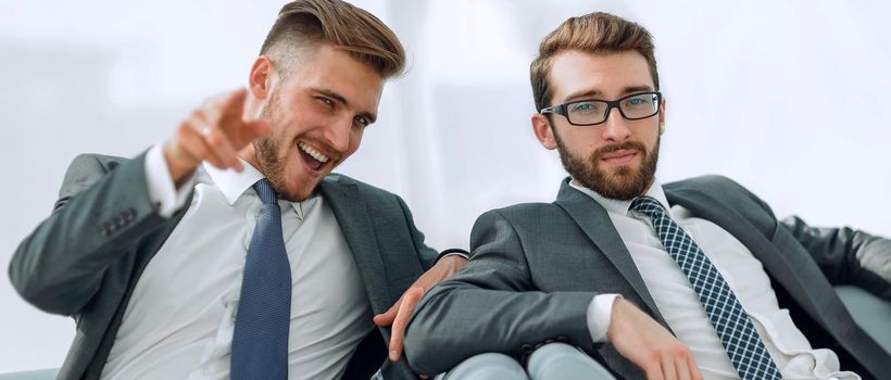 two successful business people sitting in the lobby of the office.photo with copy space