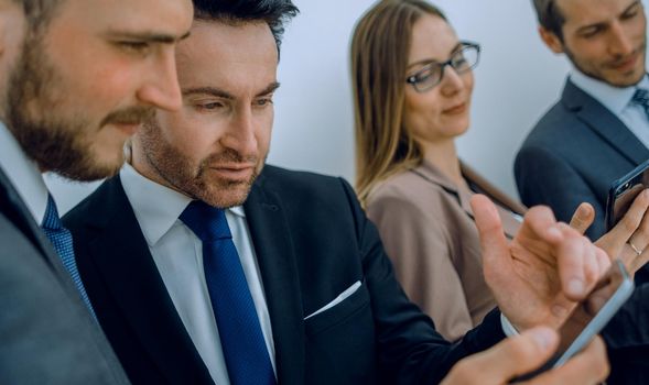 Group of young Businessman and Businesswoman looking at their smartphones and discussing for their project. Business and internet concept.