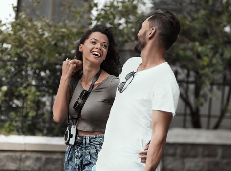 Happy young couple walking in the summer park