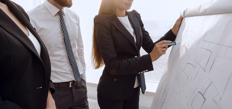 businesswoman pointing marker to flipboard on presentation in office.photo with copy space