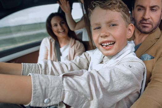 happy son driving a car. family holiday