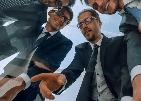 close up.a group of business partners standing near the desktop.business concept