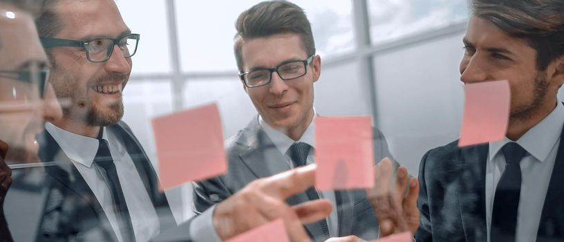 group of employees reading notes on glass.business concept