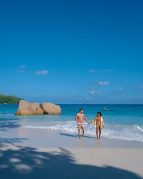 Anse Lazio Praslin Seychelles, a young couple of men and women on a tropical beach during a luxury vacation in Seychelles. Tropical beach Anse Lazio Praslin Seychelles