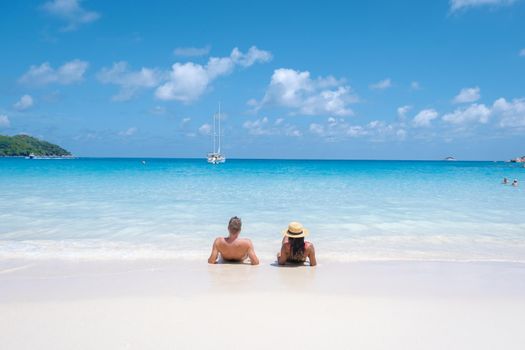 Anse Lazio Praslin Seychelles, a young couple of men and women on a tropical beach during a luxury vacation in Seychelles. Tropical beach Anse Lazio Praslin Seychelles