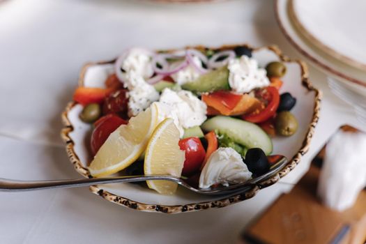 Delitious vegan greek salad with cashew cheese. Tomatoes, olives, bell pepper, cucumber, onion, in a dressing of raw black sasame oil. Raw food.