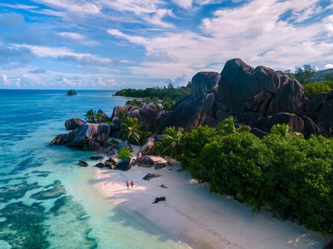 Anse Source d'Argent, La Digue Seychelles, a young couple of men and women on a tropical beach during a luxury vacation in Seychelles. Tropical beach Anse Source d'Argent, La Digue Seychelles