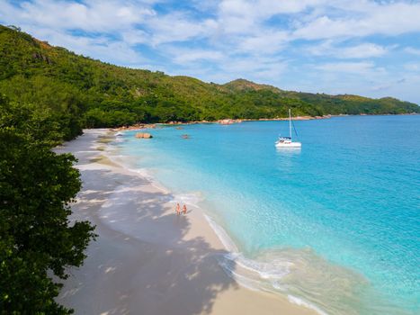 Anse Lazio Praslin Seychelles, a young couple of men and women on a tropical beach during a luxury vacation in Seychelles. Tropical beach Anse Lazio Praslin Seychelles