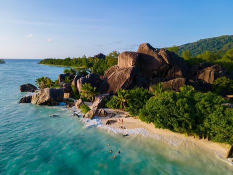 Anse Source d'Argent, La Digue Seychelles, a young couple of men and women on a tropical beach during a luxury vacation in Seychelles. Tropical beach Anse Source d'Argent, La Digue Seychelles