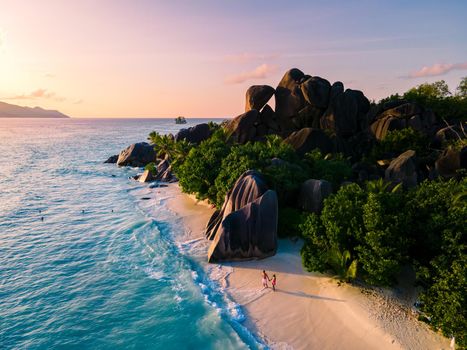 Anse Source d'Argent, La Digue Seychelles, a young couple of men and women on a tropical beach during a luxury vacation in Seychelles. Tropical beach Anse Source d'Argent, La Digue Seychelles