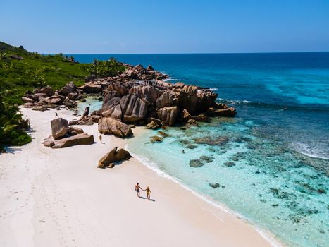 Anse Cocos La Digue Seychelles, a young couple of men and women on a tropical beach during a luxury vacation in Seychelles. Tropical beach Anse Cocos La Digue Seychelles.