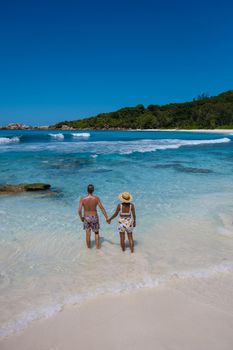 Anse Cocos La Digue Seychelles, a young couple of men and women on a tropical beach during a luxury vacation in Seychelles. Tropical beach Anse Cocos La Digue Seychelles.