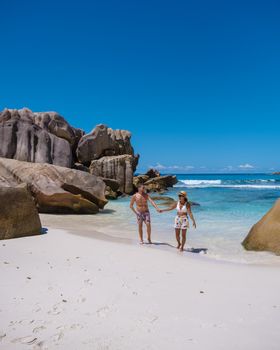 Anse Cocos La Digue Seychelles, a young couple of men and women on a tropical beach during a luxury vacation in Seychelles. Tropical beach Anse Cocos La Digue Seychelles.