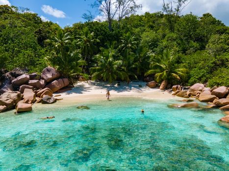 Anse Lazio Praslin Seychelles, a young couple of men and women on a tropical beach during a luxury vacation in Seychelles. Tropical beach Anse Lazio Praslin Seychelles