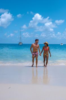 Anse Lazio Praslin Seychelles, a young couple of men and women on a tropical beach during a luxury vacation in Seychelles. Tropical beach Anse Lazio Praslin Seychelles