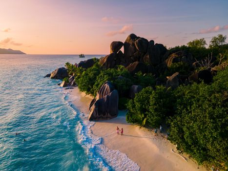 Anse Source d'Argent, La Digue Seychelles, a young couple of men and women on a tropical beach during a luxury vacation in Seychelles. Tropical beach Anse Source d'Argent, La Digue Seychelles