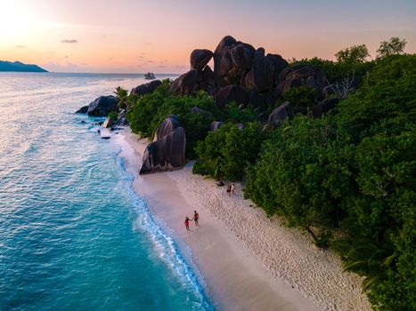 Anse Source d'Argent, La Digue Seychelles, a young couple of men and women on a tropical beach during a luxury vacation in Seychelles. Tropical beach Anse Source d'Argent, La Digue Seychelles