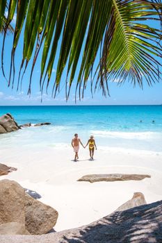 Anse Lazio Praslin Seychelles, a young couple of men and women on a tropical beach during a luxury vacation in Seychelles. Tropical beach Anse Lazio Praslin Seychelles