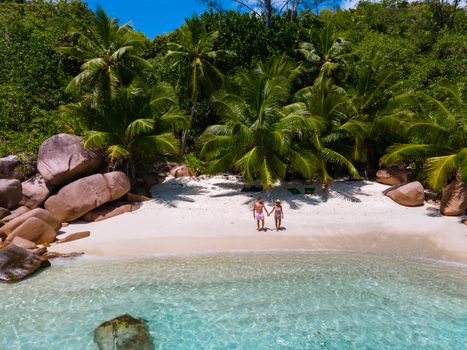 Anse Lazio Praslin Seychelles, a young couple of men and women on a tropical beach during a luxury vacation in Seychelles. Tropical beach Anse Lazio Praslin Seychelles