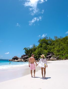 Anse Lazio Praslin Seychelles, a young couple of men and women on a tropical beach during a luxury vacation in Seychelles. Tropical beach Anse Lazio Praslin Seychelles