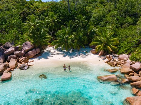 Anse Lazio Praslin Seychelles, a young couple of men and women on a tropical beach during a luxury vacation in Seychelles. Tropical beach Anse Lazio Praslin Seychelles