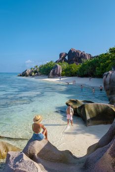 Anse Source d'Argent, La Digue Seychelles, a young couple of men and women on a tropical beach during a luxury vacation in Seychelles. Tropical beach Anse Source d'Argent, La Digue Seychelles