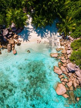 Anse Lazio Praslin Seychelles, a young couple of men and women on a tropical beach during a luxury vacation in Seychelles. Tropical beach Anse Lazio Praslin Seychelles