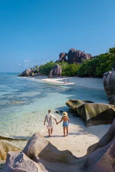 Anse Source d'Argent, La Digue Seychelles, a young couple of men and women on a tropical beach during a luxury vacation in Seychelles. Tropical beach Anse Source d'Argent, La Digue Seychelles