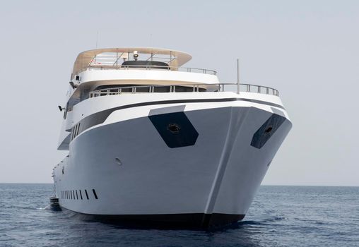A large luxury private motor yacht under way sailing on tropical sea