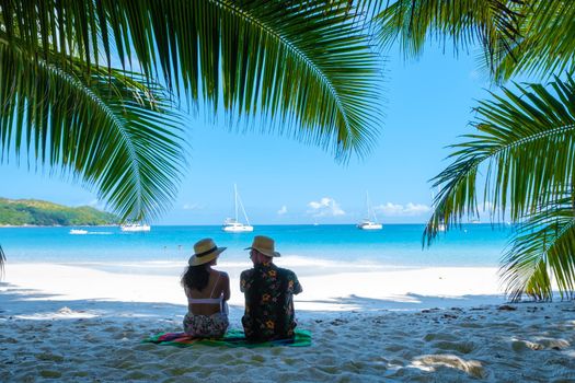 Anse Lazio Praslin Seychelles, a young couple of men and women on a tropical beach during a luxury vacation in Seychelles. Tropical beach Anse Lazio Praslin Seychelles